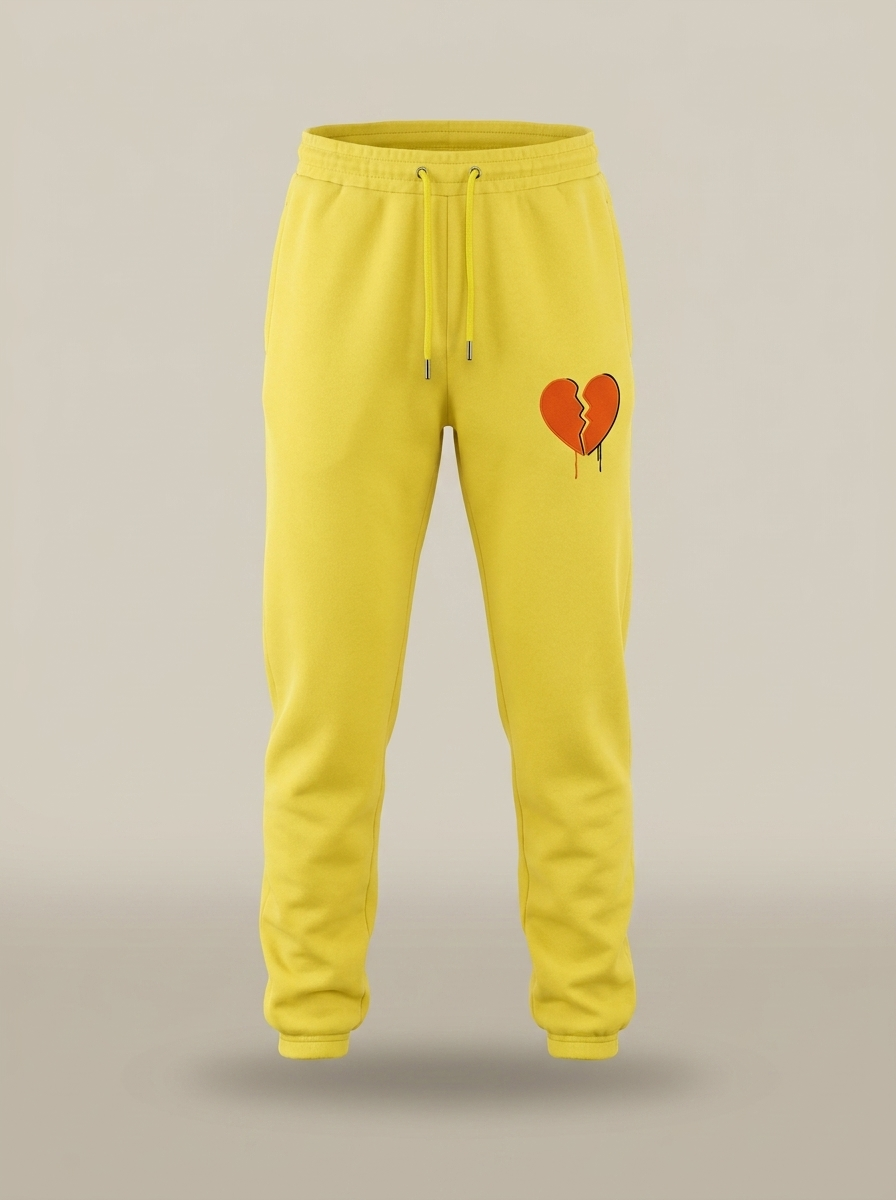 POMS x THEHOLLYROD yellow joggers with broken heart, front view
